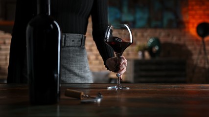 Woman tasting and drinking red wine at home