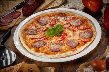 Flatlay of Italian pizza on wooden background. Rustic homemade pizzas with salami, bacon,  cheese, eggs and raw vegetables on shabby wooden background. Healthy vegetarian fungi pizza