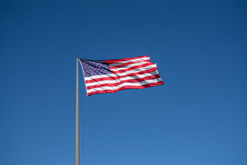 Fototapeta premium American flag waving in blue sky. Memorial Day