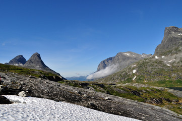 High pointed mountains in Norway with snow in the foreground - Norway