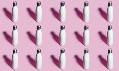 Pattern of reusable eco, steel stainless thermo water bottle white of color, isolated on pastel pink background.