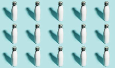 Pattern of reusable eco, steel stainless thermo water bottle white of color, isolated on cyan background.