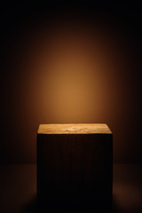 Wooden cube in the beam of light as a product display