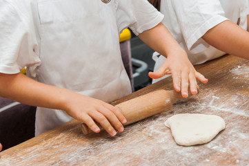 Young children make dough products. Hands closeup