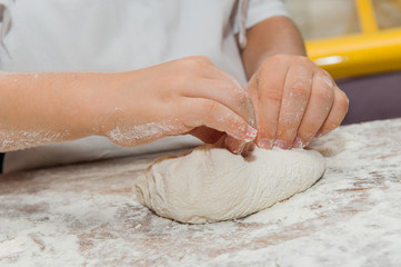 Young children make dough products. Hands closeup