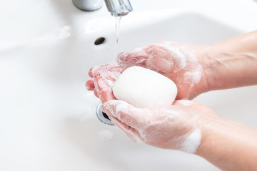 Washing hands with soap under the faucet with water