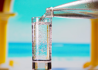 Sparkling mineral water pours from a bottle into a glass