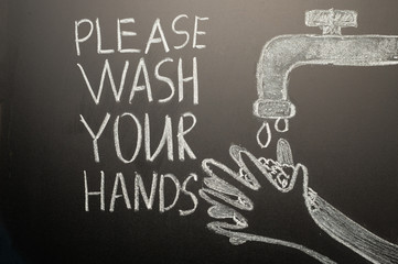 Drawing of a hand wash on the blackboard with chalk and the inscription -Please wash your hands....