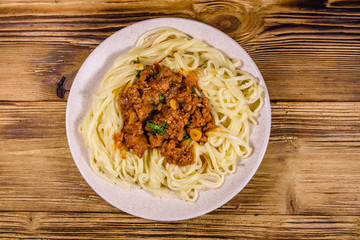 Pasta with bolognese sauce in a ceramic plate. Top view