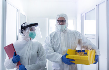 Biologist carrying samples in protective suits