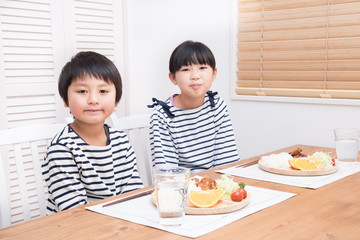 家で夕食を食べる小学生の子供