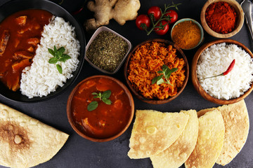Chicken tikka masala spicy curry meat food in pot with rice and naan bread. indian food on table