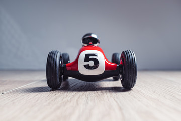 Red racing toy car with number five painted on it