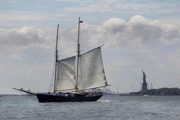 Fototapeta na wymiar Sail boat in Manhattan Bay with Statue of Liberty