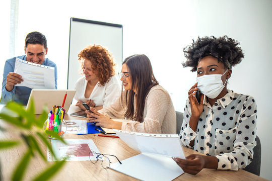 Woman having flu illness and wearing medical mask with co-workers in office. Protective measures. Not to infect. Sick office worker using protective mask not to infect his colleagues
