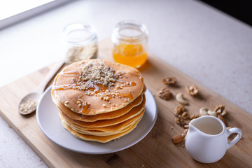 Young female chef in kitchen at home preparing american pancakes. Healthy eating