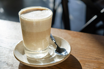 RAF coffee in a glass on the cafe table, a saucer and a teaspoon
