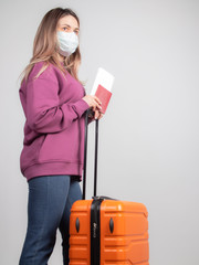 a distraught girl with a medical mask on her face is waiting for a canceled flight due to a coronavirus