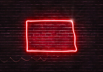 Neon sign on a brick wall in the shape of North Dakota.(illustration series)