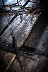Top view of bloody nails and crown of thorns in the rays of the sun as symbol of suffering and...