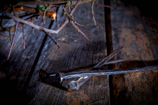 Bloody nails and crown of thorns again vintage wooden background as symbol of crucifixion of Jesus Christ.