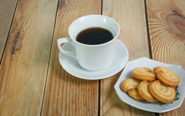 Coffee cup and cookie on wood