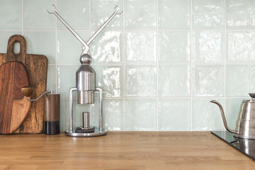 Stylish kitchen tiles wall, coffee equipment and chopping boards.