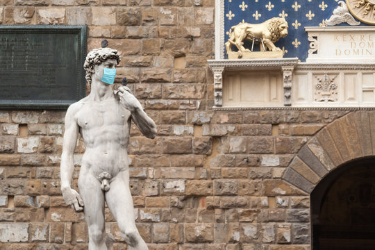 The Statue Of David in the Piazza della Signoria In Italy Wearing Blue Protective Medical Face Mask