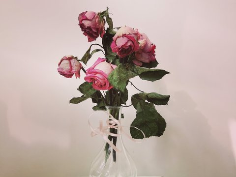 A dried bouquet of beautiful roses in a glass vase.