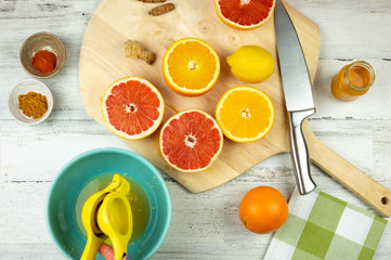Fototapeta na wymiar Squeezing fresh citrus fruit to make homemade juice