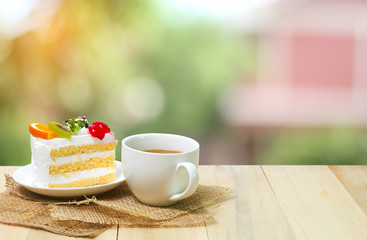 Slice cake with coffee cup on wood , green blur background