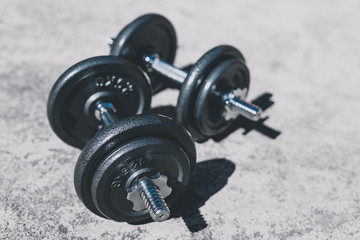 Fototapeta premium keeping fit and exercising outdoor, set of heavy dumbbells on concrete path in a backyard
