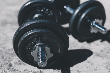 keeping fit and exercising outdoor, set of heavy dumbbells on concrete path in a backyard