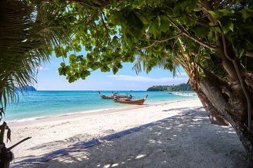 Traditional thailand longtail boats anchored at the tropical beach