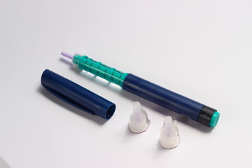 Close Up Photo, Blue and Green Insulin Pen at White Background