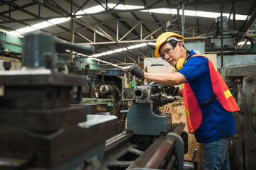 Asian Industrial workers are working on projects in large industrial plants with many devices.