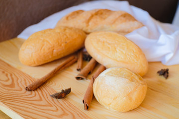 Freshly delicious breakfast baked breads on wooden table with white cloth.