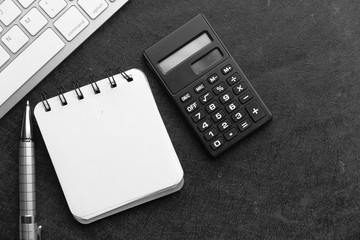 top view of calculator, notepad and pen on pink background 