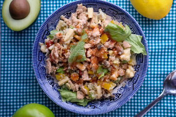 high angle view of salad and tuna fish on plate with dumbbell on table 