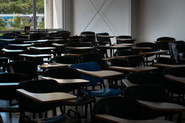 Empty classroom with single blue chair standing out