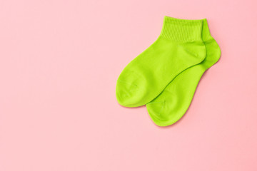 Green sports socks on a pink background. Flat lay.