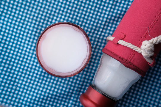 High Angle View Of Glass Of Milk And Bottle On Table 