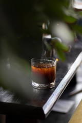 transparent glass of iced black coffee or americano on wooden table