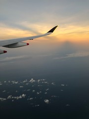 Dramatic cloudscape with the airplane's wing during sunrise from the airplane's window