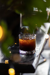 transparent glass of iced black coffee or americano on wooden table