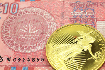 A macro image of a red ten taka note from Bangladesh with a gold coin.  Shot close up.