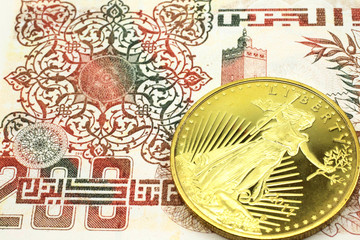 A macro image of a beige Algerian dinar note with a gold coin.  Shot close up.