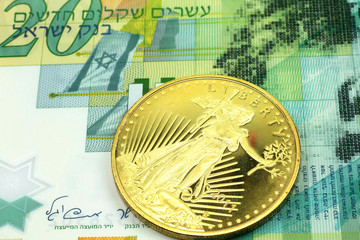 A macro image of a green twenty shekel note from Israel with a gold coin.  Shot close up.