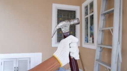 Hand wear the glove and holding the hammer