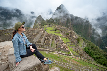 Young Asian woman traveler looking at Machu Picchu, one of seven wonders and famous tourist attraction in Cusco Region of Peru. This majestic place has known as 'Lost City of the Incas' © zephyr_p